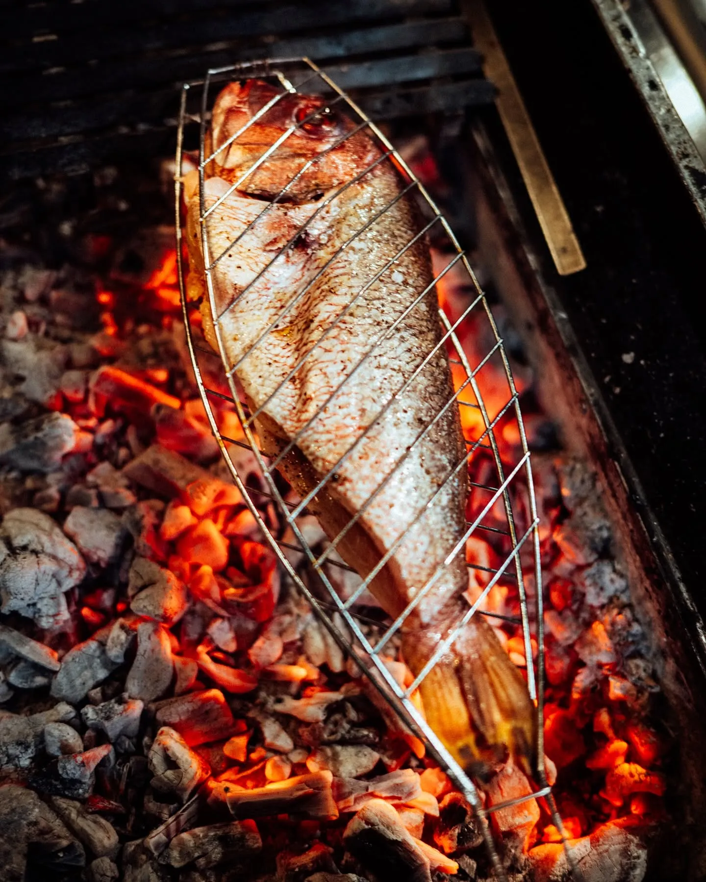 Poisson entier grillé sur le charbon de bois